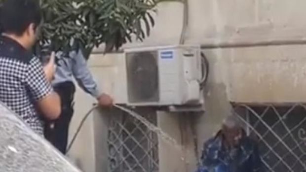 Bakıda polis küçədə yatan kişini çimizdirdi – VİDEO