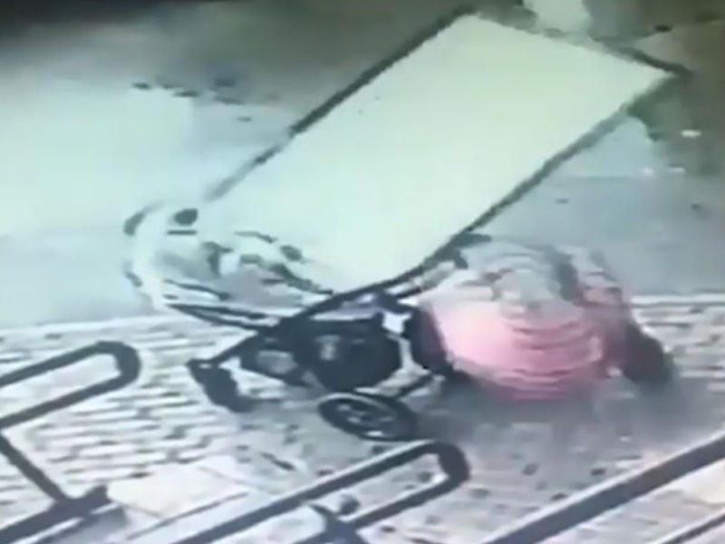 Küçədə qorxulu anlar: Uşaqlı qadının başına şüşə düşdü - VİDEO