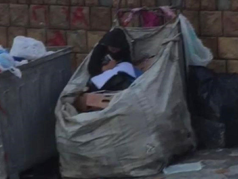 Küçədə təsirli görüntü - Kağız toplayan uşaq zibillikdən tapdığı kitabı həvəslə oxuyur - FOTO