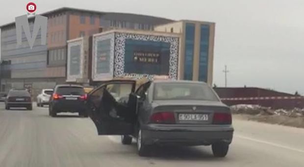 Bakıda taksi sürücüsü maşını qapısı açıq idarə edib - VİDEO