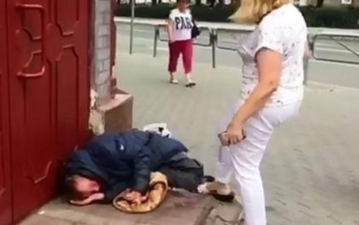 Xanım məmur küçədə yatan “bomj”u belə vurdu - VİDEO