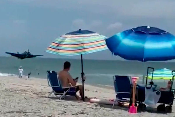 Военный самолет приземлился на пляже в нескольких метрах от отдыхающих - ВИДЕО