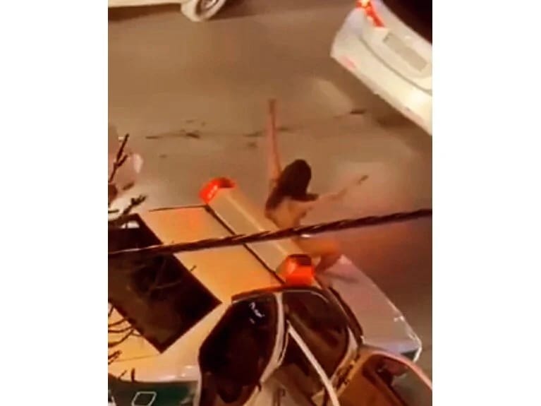 İranda gənc qadın soyunaraq polis maşınının üstünə çıxıb