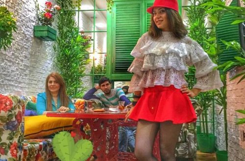 Ayan qırmızı mini ətəkdə ayaqlarını göstərdi