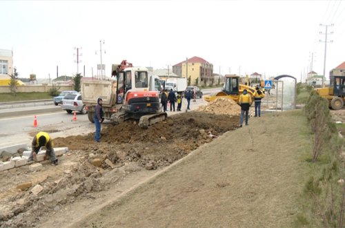 Avtomobil yolunun kənarında piyada səkiləri tikilir