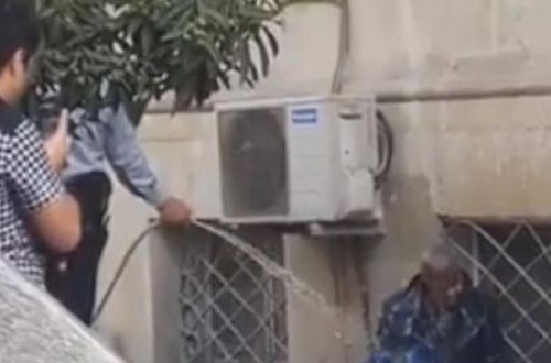 Bakıda polis küçədə yatan kişini çimizdirdi – VİDEO