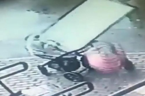 Küçədə qorxulu anlar: Uşaqlı qadının başına şüşə düşdü - VİDEO