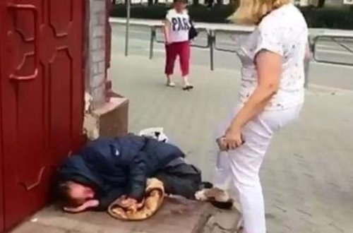 Xanım məmur küçədə yatan “bomj”u belə vurdu - VİDEO