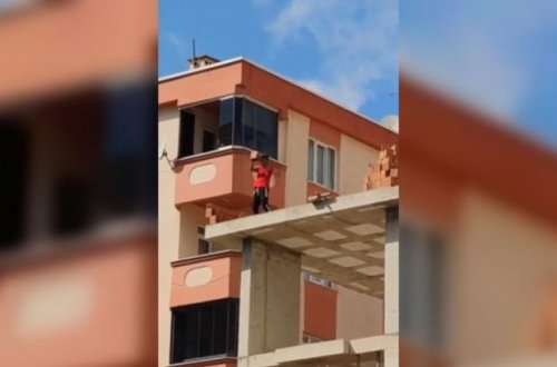 Tikilinin üzərinə çıxaraq insanlara kərpiclə xəsarət yetirməyə çalışdı – VİDEO