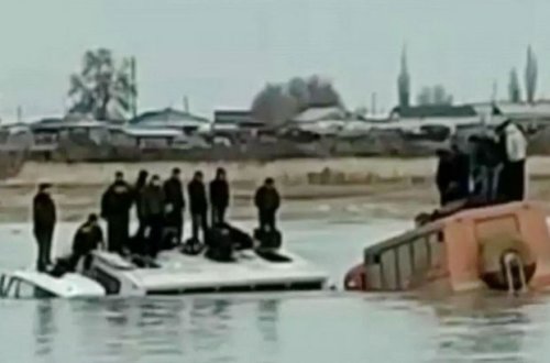 Buz qırıldı: Fəhlələr çayın ortasında avtobusun damında kömək gözlədi - VİDEO